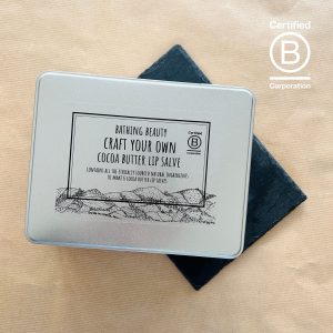 A large, silver hinged lid, gift tin, containing all the ingredients to make 6 Full size Cocoa `butter Lipslick. The label has an original illustration of The Clwydian Range